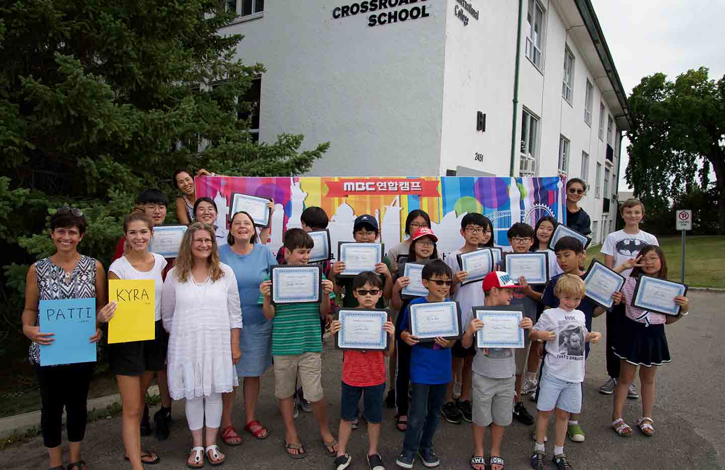 Students receive their certificates outside the school